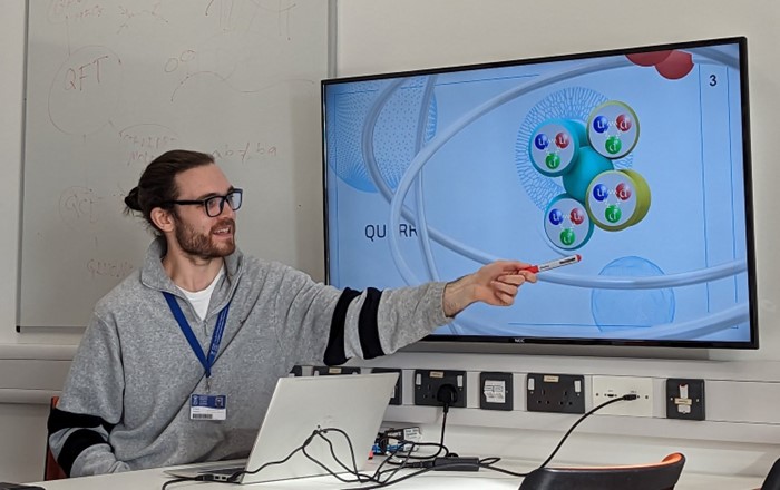 Young man pointing at a large computer screen showing a mathematical problem